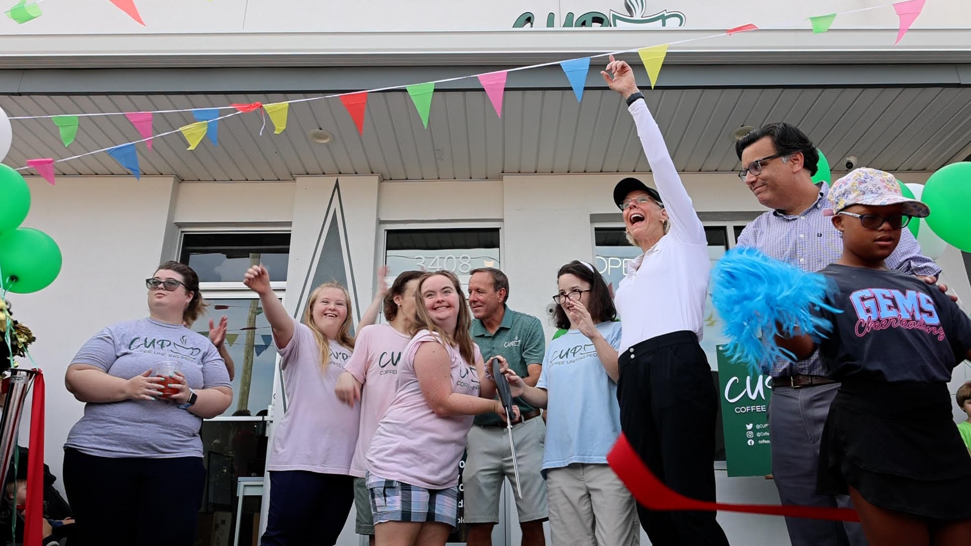 Ribbon-cutting ceremony at the South Tampa flagship with team members, balloons, and party flags